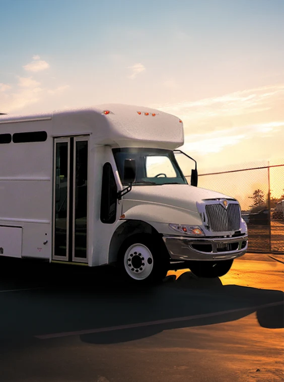 White shuttle bus parked next to a security fence at a prison near Sacramento